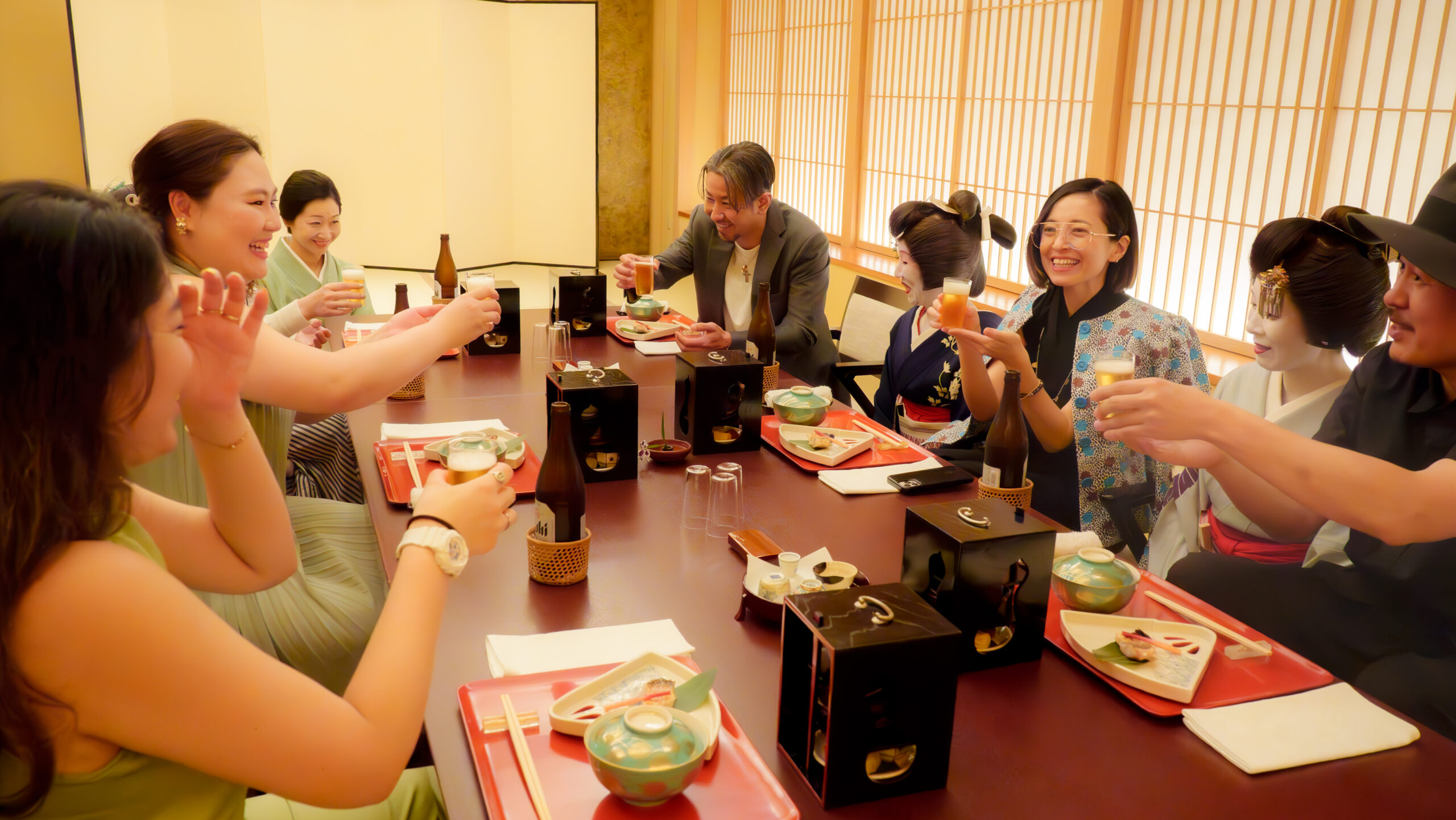 都鳥のお座敷で、芸者衆とお客様が膳を囲んで杯を交わす場面