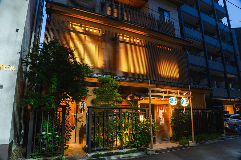 夕暮れの都鳥の店構え。格子窓から灯りがもれる浅草の待合茶屋