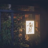 夜の浅草 都鳥の店先。行灯に「都鳥」の文字が灯り、格子戸と植栽が並ぶ