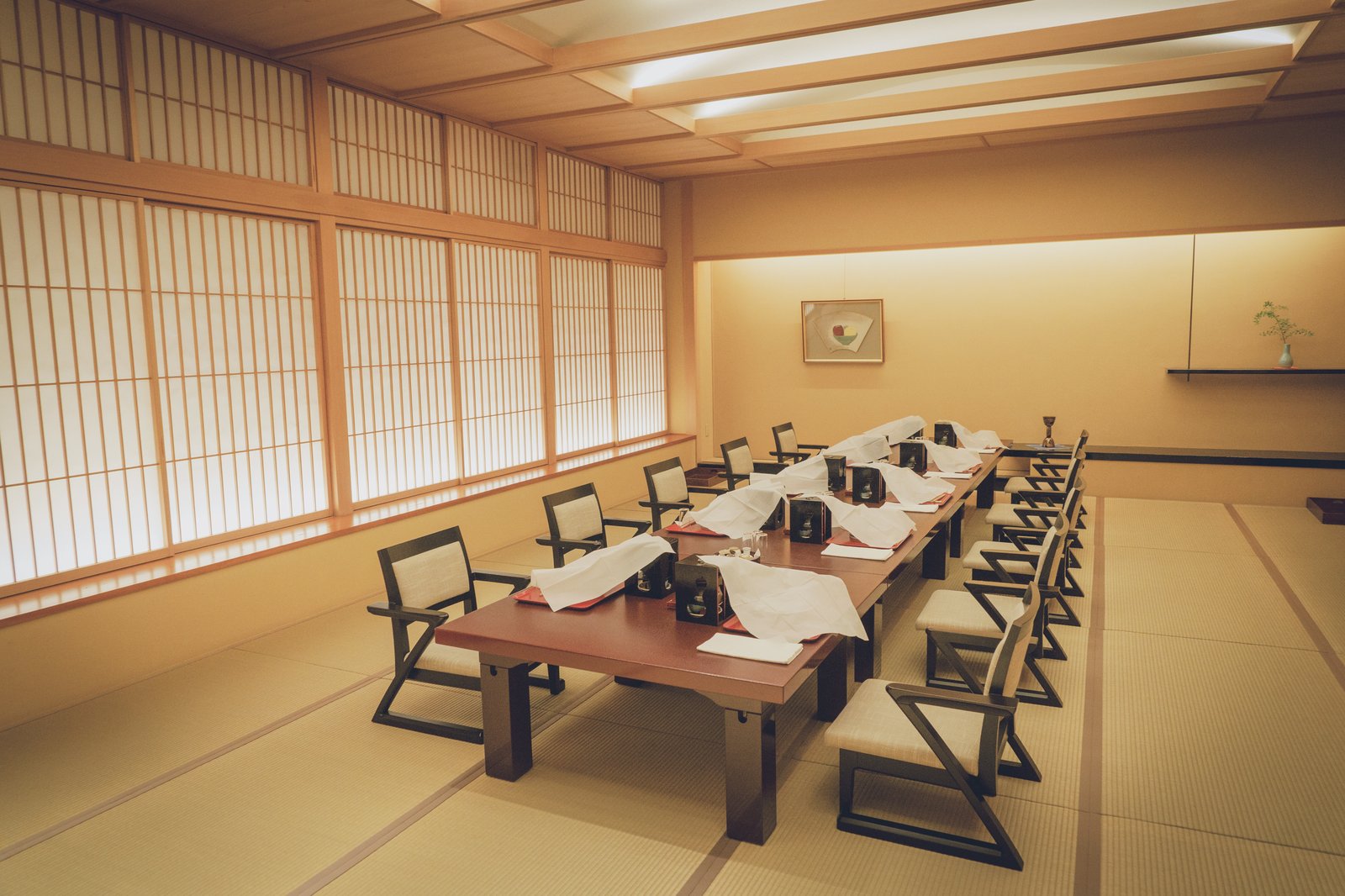 都鳥の広間。畳の上に長いテーブルと椅子が並び、奥の床の間に掛け軸と生け花
