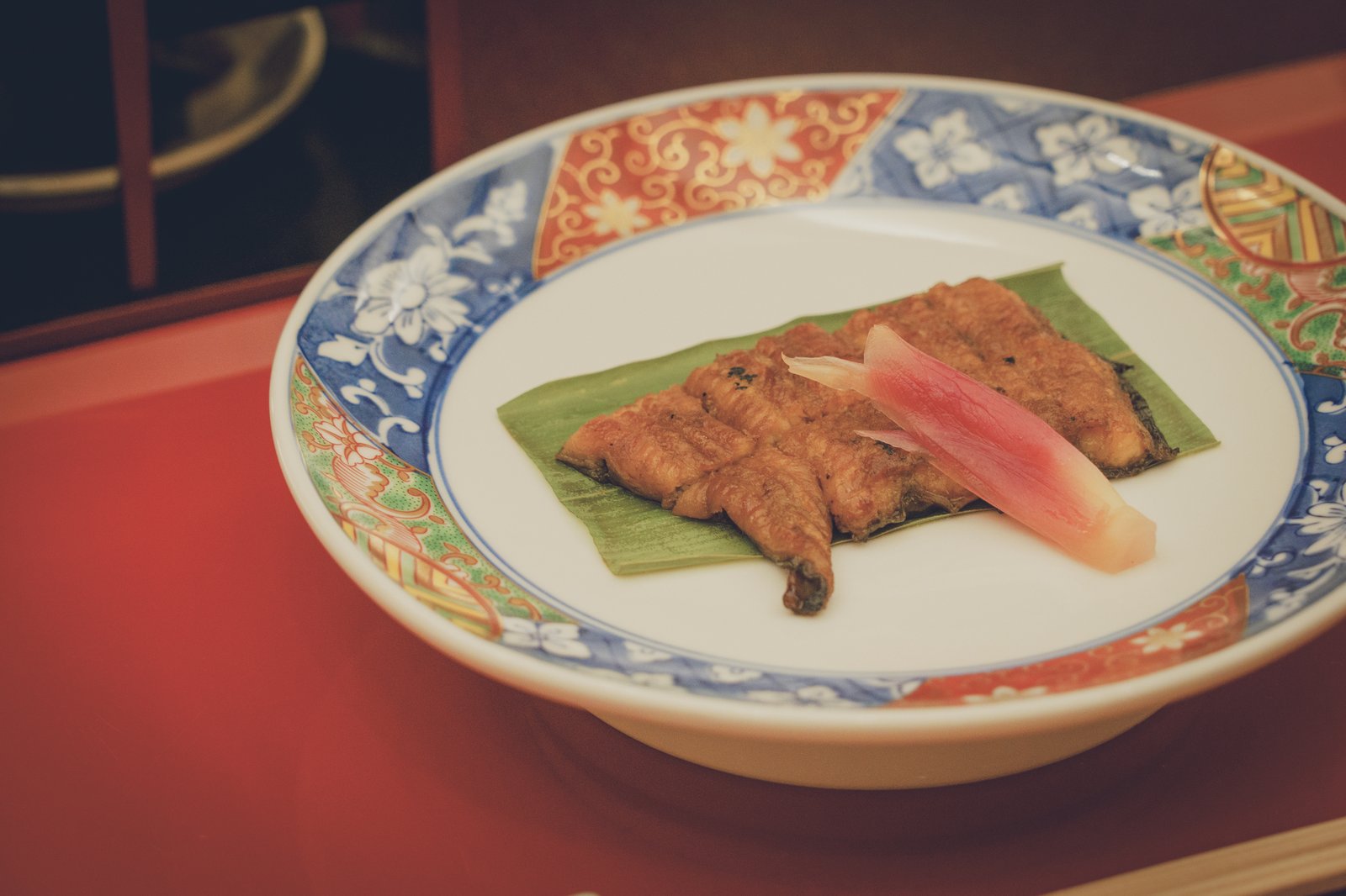 都鳥の会席料理。朱塗りの膳に載せた染付の器に、笹を敷いた焼き物