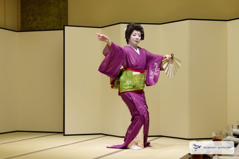 両腕を広げて扇を構える芸者の舞