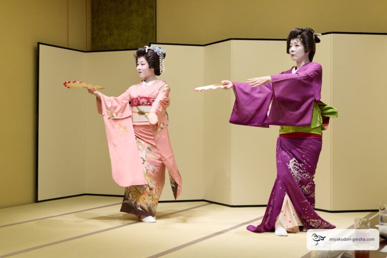 二人の芸者が扇をそろえて差し出す舞
