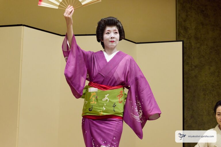 扇を頭上に掲げる芸者