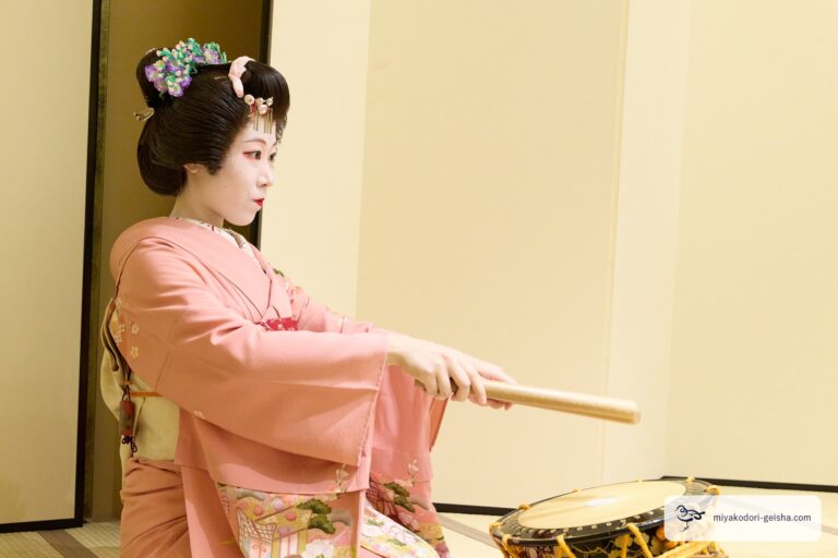 撥（ばち）で太鼓を打つ芸者