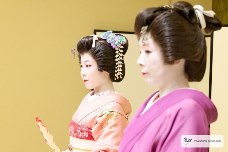 並んで前を向く二人の芸者。花かんざしと日本髪