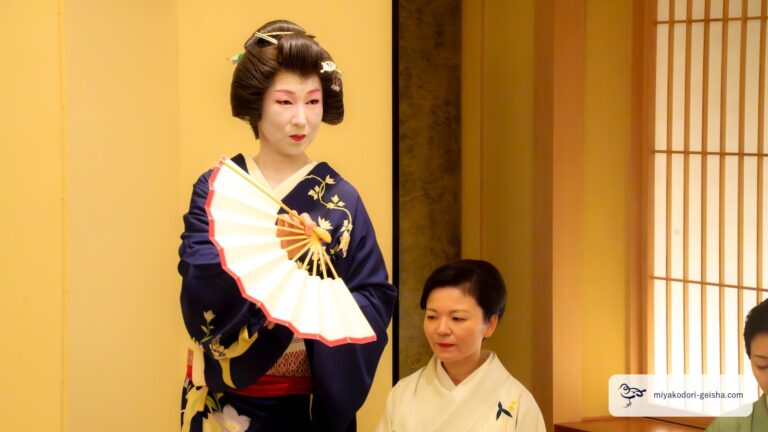 扇を開いて舞う芸者