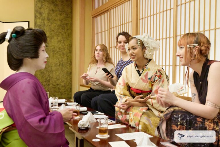 障子の前の席で芸者とお客様が歓談する