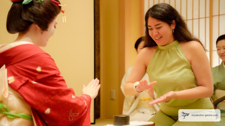 笑いながら金毘羅船々の手を出す女性と芸者